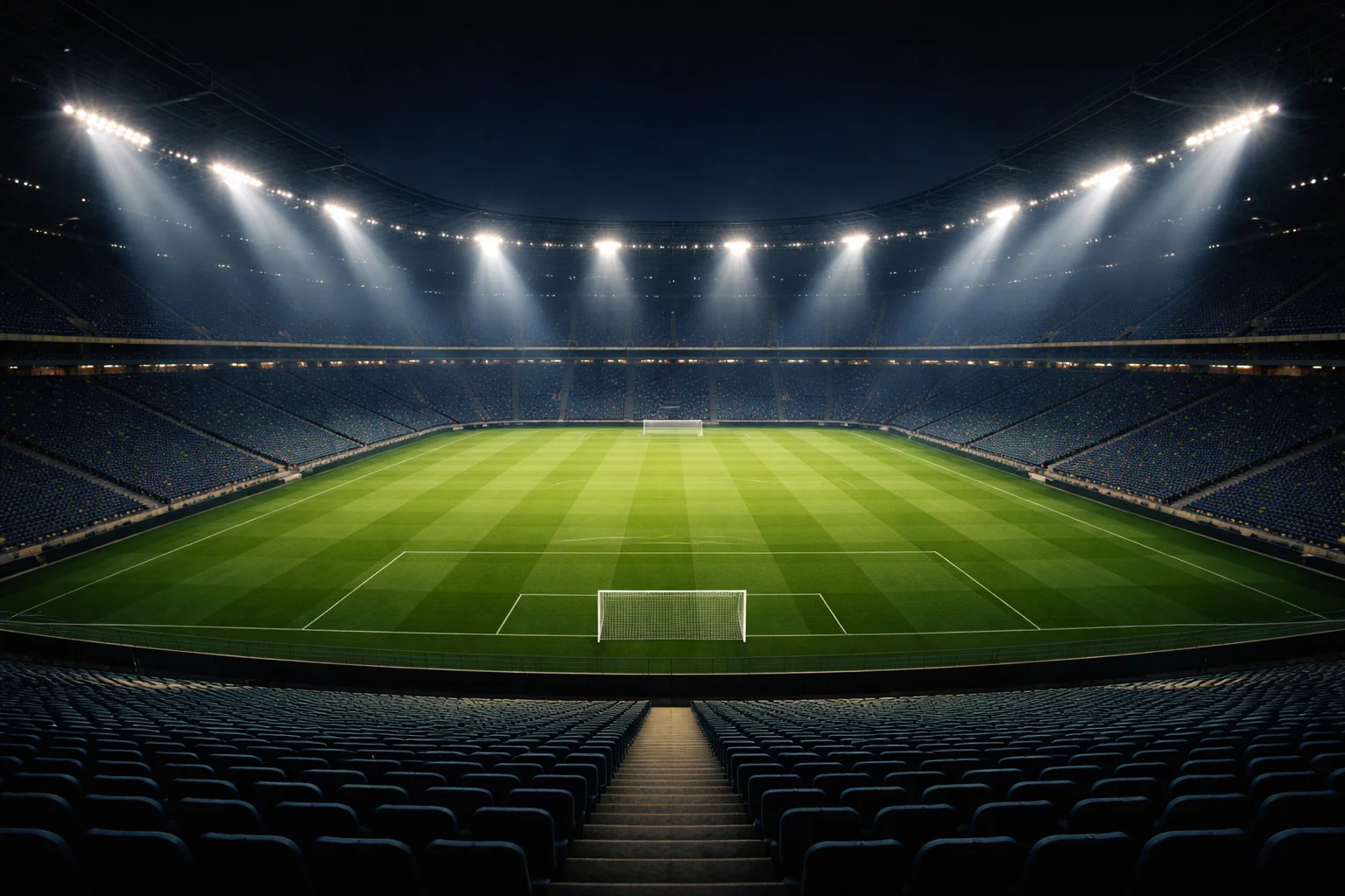 Stadio di calcio illuminato di notte con riflettori accesi sul campo verde